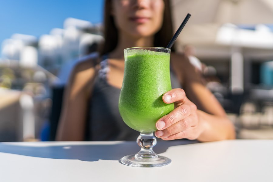 Healthy juicing lifestyle trend woman drinking green spinach jui
